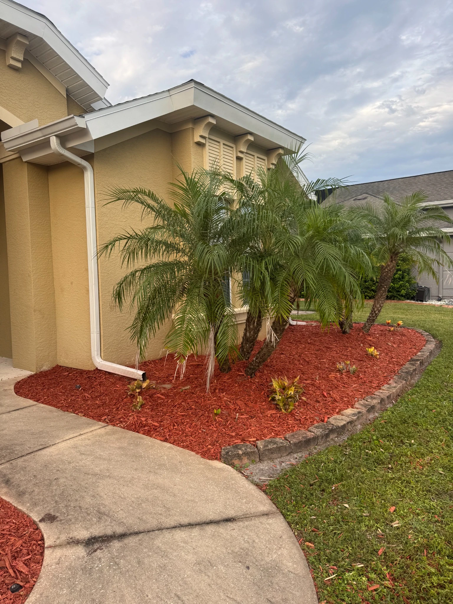 Side landscape bed with fresh red mulch after restoration