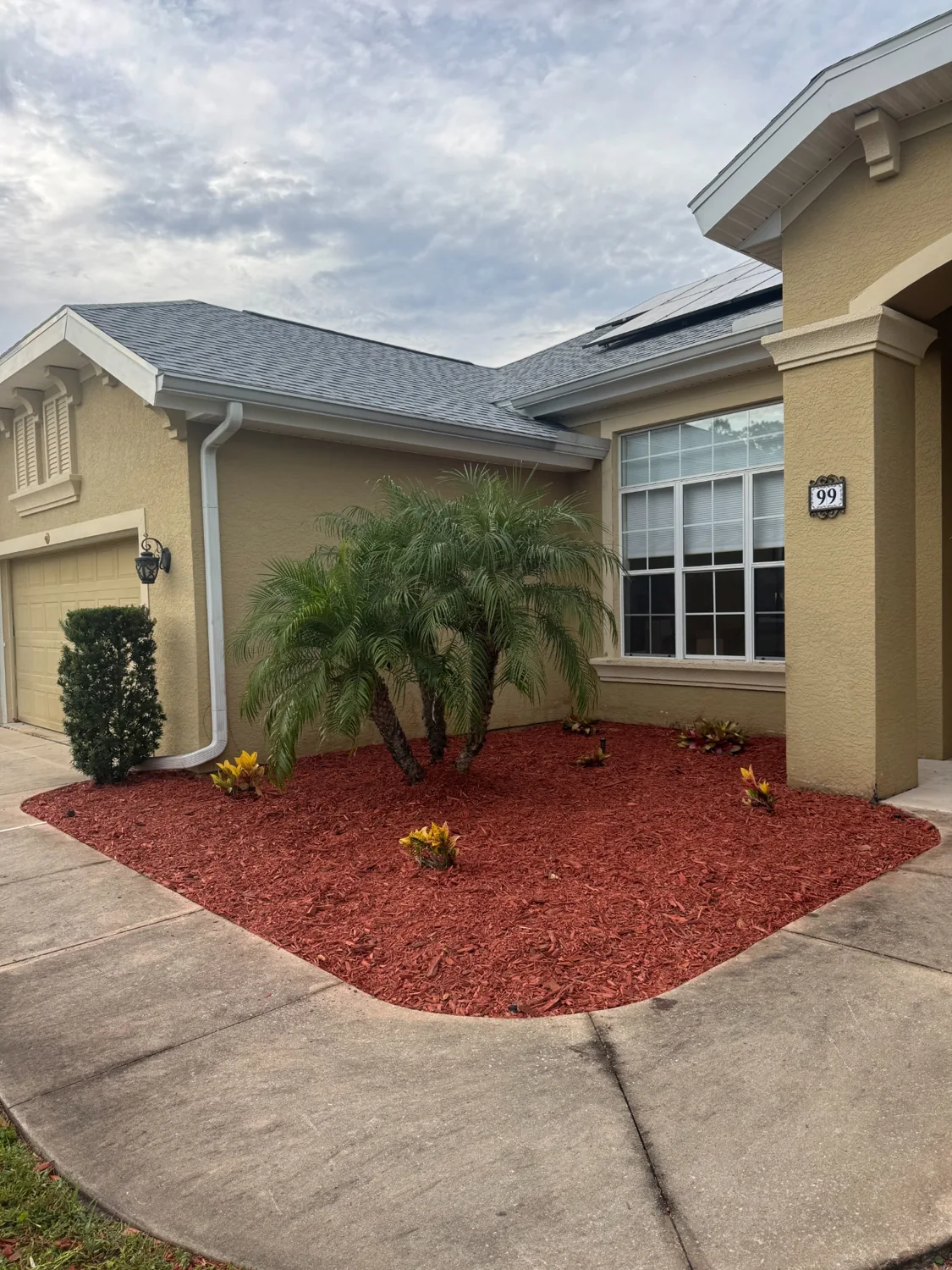 Front landscaping bed after weed removal and fresh red mulch installation